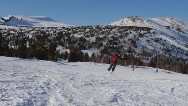 Счастливая женщина лыжник протягивает руки к сторонам имитируя полет катание на лыжах вниз по склону — стоковое видео