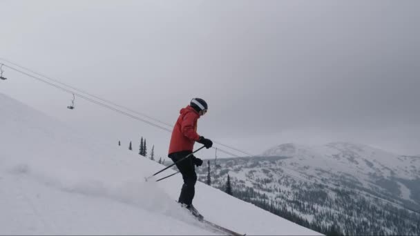 Esqui profissional Esqui para baixo uma inclinação nevada íngreme nas montanhas no resort de esqui — Vídeo de Stock