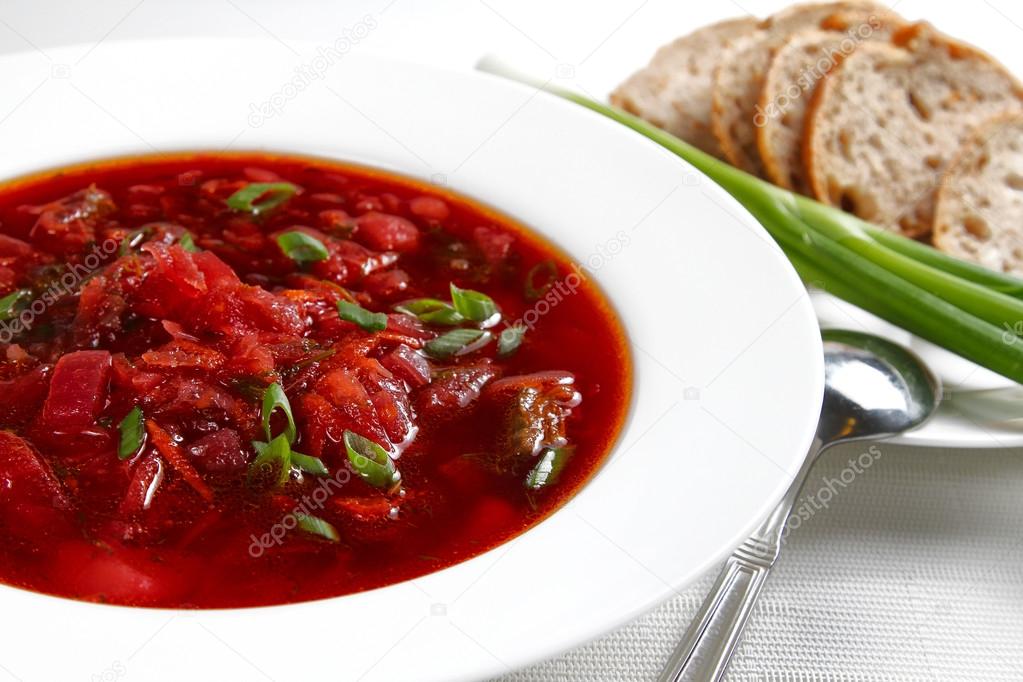 Russian beet and cabbage soup in a white bowl, shallow focus