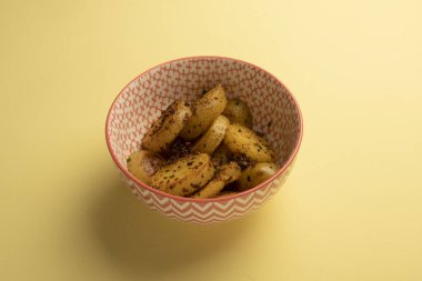 Sarı masadaki baharatlarla tatlandırılmış patates salatası.