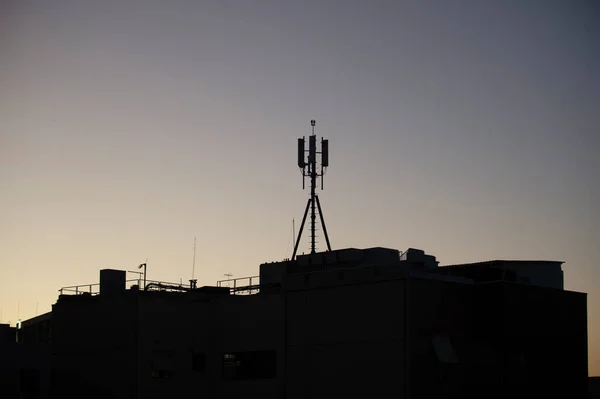 Cellular Transmitters Top Building Silhouetted Late Afternoon — Stock Photo, Image