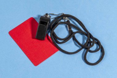 Kırmızı kart ve hakem düdüğü ile mavi arkaplanda metin için boşluk