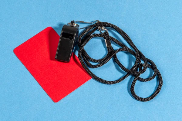 Kırmızı kart ve hakem düdüğü ile mavi arkaplanda metin için boşluk