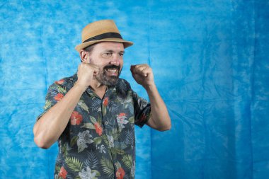 Turist gibi giyinmiş, yüzünde baskılı tişört ve ifadeler olan biri.