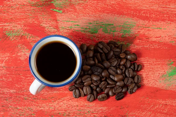 Pequeña Taza Café Con Frijoles Lado Mesa Roja Rústica —  Fotos de Stock