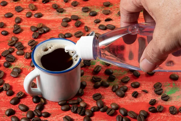 Pequeña Taza Café Con Frijoles Lado Mesa Rústica Roja Siendo —  Fotos de Stock