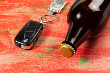 Alkol kullanımı ve araba sürme tehlikesi anahtar ve şişeyle sembolize ediliyor