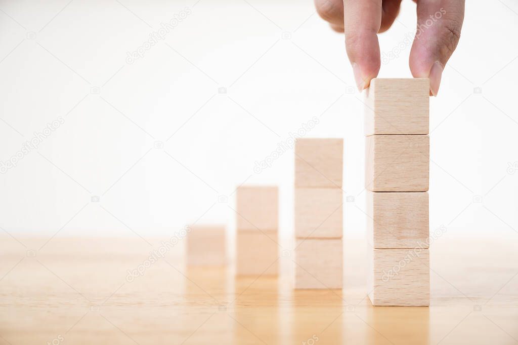 Hand arranging wood block stacking as step stair. Ladder career path concept for business growth success process, Copy space