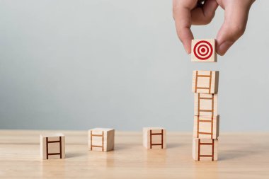 Tahta masa ile ahşap bloğu üst üste dizme el düzenlemesi. Hedeflere ulaşmaya çalışma kavramı