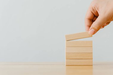 Tahta masa ile ahşap bloğu üst üste dizme el düzenlemesi. Büyüme süreci için iş konsepti