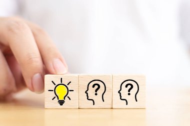 Yaratıcı fikir ve yenilik kavramı. İnsan sembolü ve ampul simgesi olan tahta bloğu elle seç