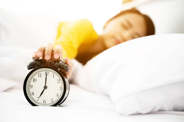 아시아인 여성은 아침에 일어납니다 침대에 누워서 자명종 시계를 끄려고 있어요 — 스톡 사진