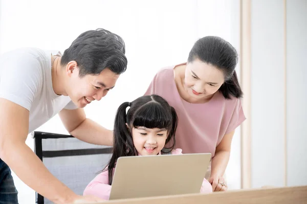 Asian girl student online learning class study using laptop and parent take care. Concept of online education and homeschool