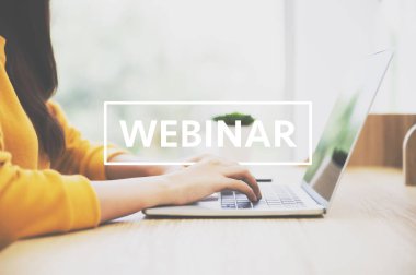 Ahşap masada bilgisayar kullanan bir kadın. Evde çalışıyor, webinar izliyor ve laptopla çalışıyor.