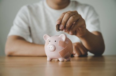 Domuz kumbarasına ahşap masaya para koyuyorum. Tasarruf ve finans sektörü yatırımı kavramı