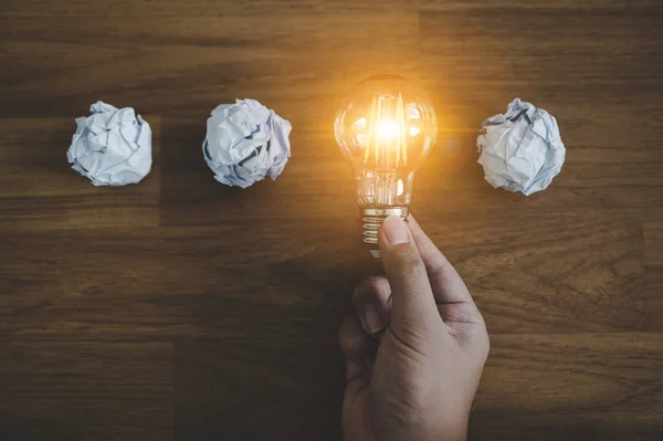 Hand Välja Glödlampa Och Skrynkliga Kontorspapper Begreppet Inspiration Kreativt Idétänkande — Stockfoto