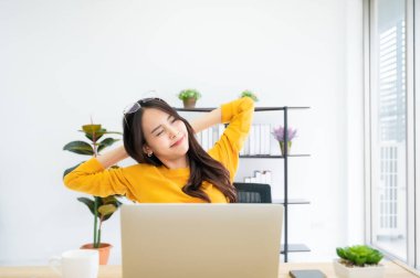 Ofis sendromu konsepti. Bilgisayarda uzun süre çalıştıktan sonra boyun ağrısı çeken Asyalı genç bir kadın.