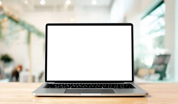 Ahşap masadaki laptop boş ekran bulanık kahve dükkanının iç fonu ve aydınlatma bokeh, model, metin için şablon, arka plan ve aygıt ekranı için kırpma yolları dahil