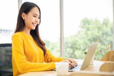 Evde çalışmak, video konferansı, çevrimiçi görüşme videosu bilgisayar ekranına bakan güzel Asyalı kadın Webinar izlemek ve evde dizüstü bilgisayarla çalışmak.