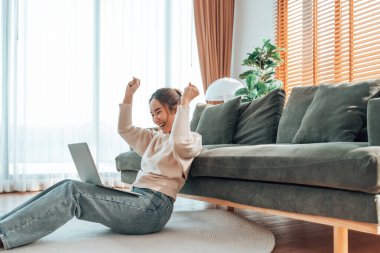 Asyalı bir kadının kazanmasını ya da bilgisayar laptopunda ecommerce alışveriş teklifi almasını kutlayan komik bir coşku. Heyecanlı mutlu kız kazanan başarıyı kutlayan deftere bakıyor.