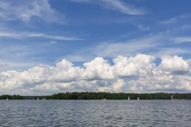 Polonya Masuria 'da göl, güneşli bir günde yelken açmak. Resimli bulutlu gökyüzü, Masurian Lakeland, Polonya