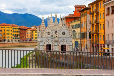 Pisa, Italy- 11 Mayıs 2019: Arno nehri kıyısındaki Santa Maria della Spina Kilisesi ve renkli bina