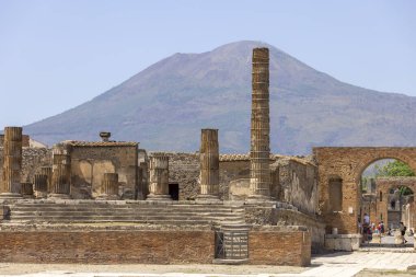 Pompeii, Napoli, İtalya - 26 Haziran 2021: M.S. 79 'da Napoli yakınlarında Vesuvius volkanının patlaması sonucu yıkılan antik bir şehrin kalıntıları. Jüpiter Tapınağı ve Vezüv Dağı manzarası 