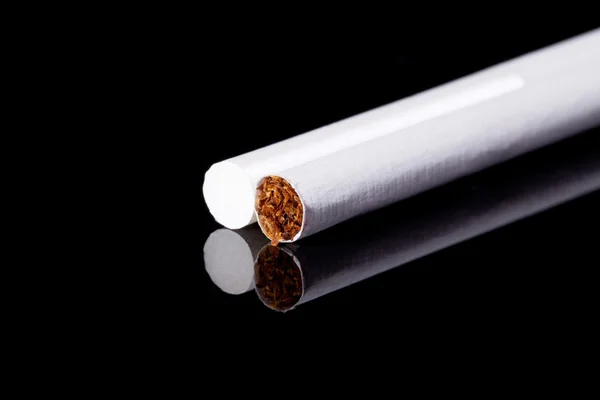 Two thin cigarettes isolated on black background macro — Stock Photo, Image