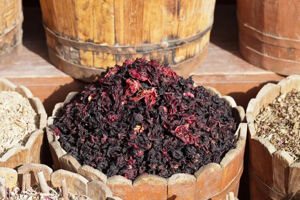 Dried hibiscus petals in wooden container on street stall — Stock Photo, Image