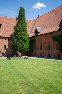 Malbork, Polonya - 25 Haziran 2020: 13. yüzyıl Malbork Kalesi avlusu, Nogat Nehri 'ndeki ortaçağ Töton kalesi. Dünyadaki en büyük gotik şato, UNESCO Dünya Mirası Sitesi.