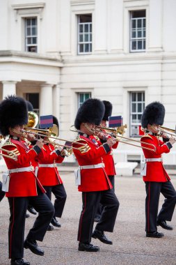 Londra, Birleşik Krallık - 25 Haziran 2017: Buckingham Sarayı önünde düzenlenen geleneksel Muhafız Değişimi töreninde Kral Muhafızları. Kırmızı üniformalı ve sembolik ayı postlu kraliyet muhafızları.