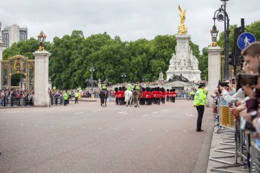 Londra, Birleşik Krallık - 25 Haziran 2017: Kral Muhafızları Değişim Töreni sırasında Kraliçe Victoria Anıtı 'nın önündeki Buckingham Sarayı' nda. Polis memurları düzeni sağlıyor.