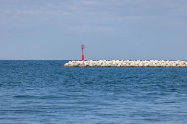 Adriyatik Denizi kıyısındaki Obala Marsala Tita kıyısında deniz trafiği, Porec, Hırvatistan ve Istria 'ya yol gösteren kırmızı navigasyon feneriyle işaretlenmiş taş kırma hattı.