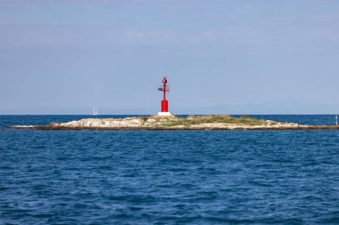 Adriyatik Denizi kıyısındaki Obala Marsala Tita kıyısında deniz trafiği, Porec, Hırvatistan ve Istria 'ya yol gösteren kırmızı navigasyon feneriyle işaretlenmiş taş kırma hattı.