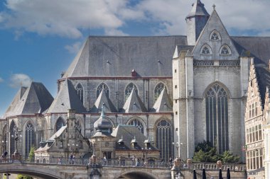 Gent, Belçika - 19 Mayıs 2023: Lys nehri kıyısındaki Gotik Aziz Michael Kilisesi (Sint-Michielskerk) ve ünlü kemerli Aziz Michael Köprüsü