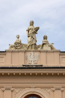 Lublin, Polonya - 23 Mayıs 2022: Polonya arması ve kartalın rahatlığı ile bölge mahkemesinin klasik binasının cephesi. Üstte üç tane alegorik heykel var.