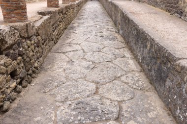 Herculaneum, Campania, İtalya - 29 Haziran 2021: Antik Roma şehrinin kalıntılarındaki Paved sokağı M.S. 79 'da Napoli yakınlarındaki Ercolano Arkeoloji Parkı' nda meydana gelen Vesuvius volkanı patlaması sonucu yıkıldı.