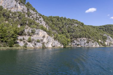 Krka Nehri 'nin sakin güzelliği, Hırvatistan' ın ormanlar ve turkuaz sularıyla çevrili Skradin 'den Krka Ulusal Parkı' na Skradinski Buk şelalesiyle seyahat ediyor