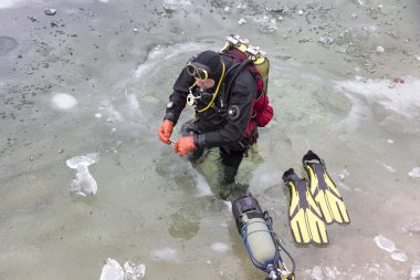 Dalgıç buz-l donmuş yüzeyin altında dalış için hazırlanıyor