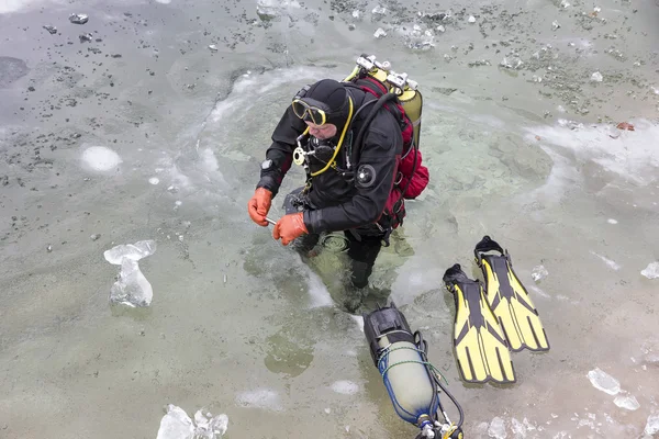 diver preparing for the ice-diving under the frozen surface of l