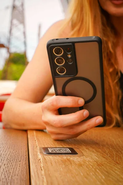 Telefon kadının elinde. QR Tarayıcı Restoran menüsü