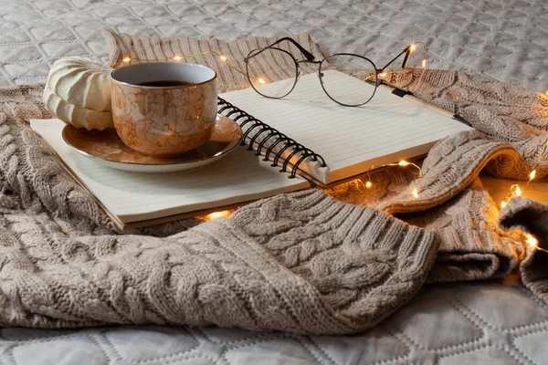 Sıcak ev atmosferi. Sıcak bej kazak, kahve bardağı, kitap. 