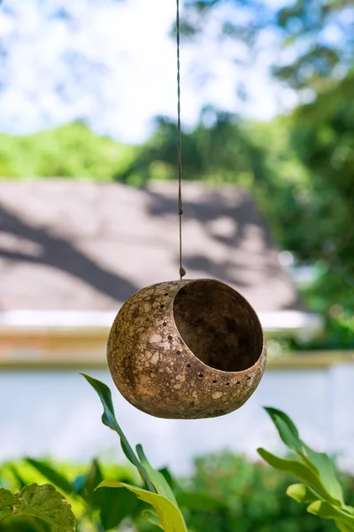 Птичье гнездо кормушки на открытом воздухе висит на веревке с крыши — стоковое фото
