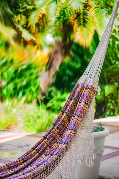Bahçe veranda kare kompozisyon tarafından asılı boş renkli kumaş ve ip hamak — Stok fotoğraf