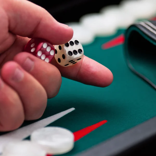 Backgammon player's hand holding the dice square — Stock Photo, Image