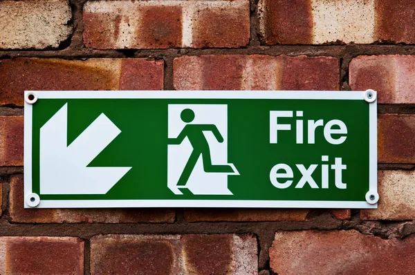 Fire exit sign on the red clay brick wall — Stock Photo, Image