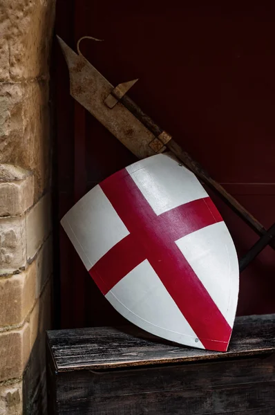 Középkori Angliában zászló pajzs és fegyver nyugszik a fal mellett Jogdíjmentes Stock Fotók