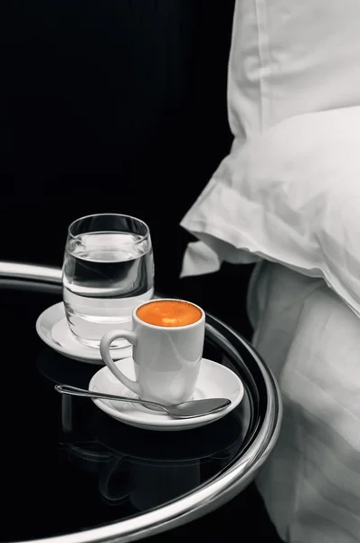 Espresso coffee full cup and glass of water on bedside table closeup — Stock Photo, Image