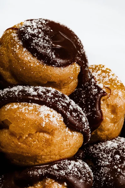 Profiteroles in einem Haufen voller belgischer Schokolade Nahaufnahme — Stockfoto