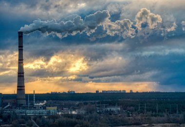 Güneş doğarken fırtınanın altındaki elektrik santrali.